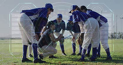 Gathering baseball players huddling on outfield grass in uniforms, with bat, gloves, catcher\'s gear