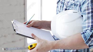 Builder with measuring tape on site
