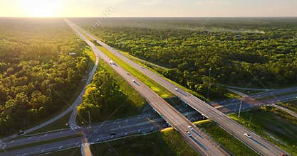 Sunrise over multilane freeway system in Florida with fast moving cars and trucks traveling the I-75 highway