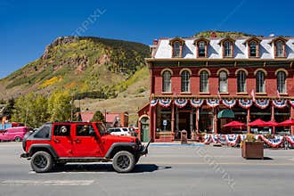 Red jeep car on the main road of Silverton downtown with historic buildings