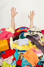 Man hands reaching out from a big pile of clothes and accessories.