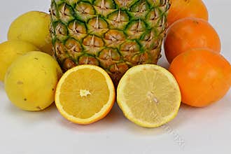 Appetizing pineapple surrounded by fresh oranges and lemons