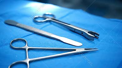 Close Up Surgical Tools on Blue Surgical Sheet Including Scissors Forceps and Scalpel for Medical Procedures and Hospital