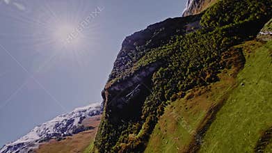 An aerial view of a helicopter performing a cargo flight with cargo slings in the mountains. Shot high in the mountains.