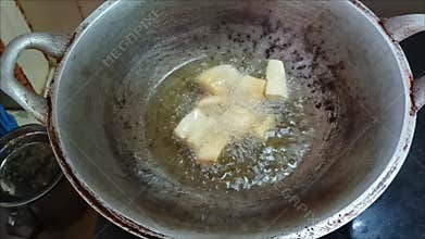 Fry fresh cassava pieces in a pan