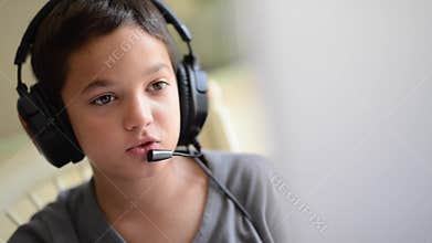 Child happy listen music and playing on the computer with headphones outdoor