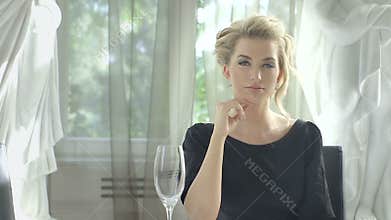 Attractive blonde woman waiting at the restaurant table