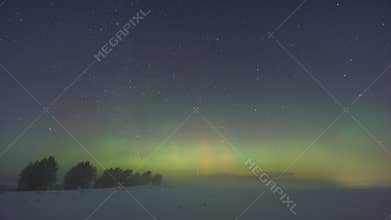 Bright northern lights dance over icy fields under starlit sky, Spectacular display of green and red auroras shimmering over