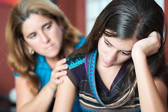 Mother comforts her teen daughter