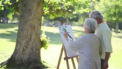 Mature couple painting trees