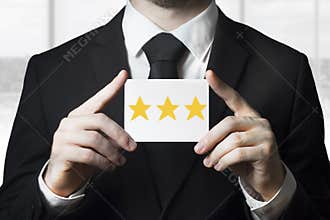 Businessman holding sign three golden rating stars