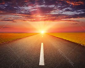Driving on an empty asphalt road at sunset