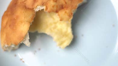 One slice of cheese-flavored bread with an irregular, asymmetrical shape is rotating on a clean white isolated background