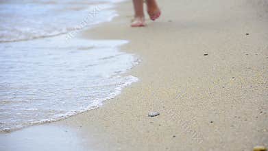 Young Woman making Footprints at the Beach sand