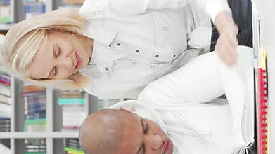 Supportive young woman assisting her college friend with an assignment