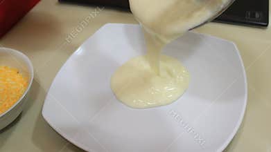 Pouring Smooth Creamy Sauce onto White Plate