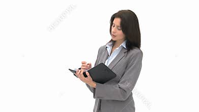 Pensive businesswoman writing on her agenda