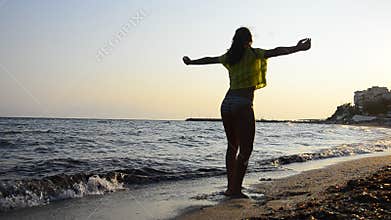 Human, Beautiful young girl turns spiritual on a beach sand at sunset