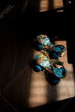 Sunlight Illuminates a Pair of Old Roller Skates on a Dark Wooden Floor