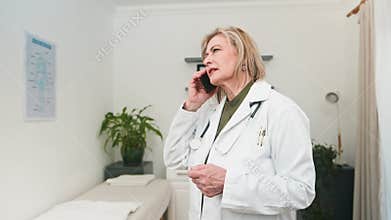 Experienced Female Doctor Engaged in a Professional Phone Consultation within a Modern Clinic Setting