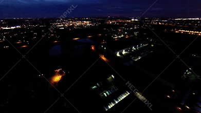Night view of house lights, streets and buildings from in air flight above ground