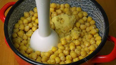 Close-up of a blending chickpeas by hand blender. Vegan food