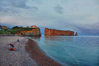 End of the day on the beach of Percé with other tourists looking at the landscape