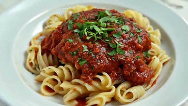 Delicious pasta dish with rich tomato sauce and fresh parsley served on a white plate today