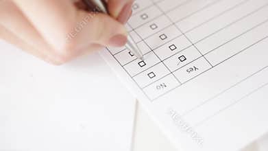 Hands filling checklist and answering with no