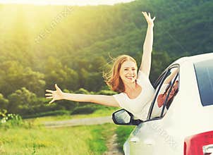 Happy woman looks out the car window on nature