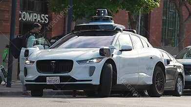 Waymo Jaguar I PACE at curb with sensors and indicator in California