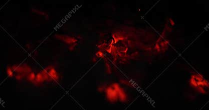 Close-up view of glowing embers and ashes creating