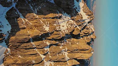 Rocky snow mountains at sunrise aerial