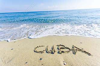 Word CUBA written in the wet sand