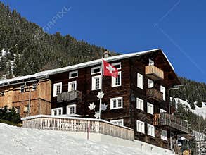 Old traditional swiss rural architecture and alpine livestock farms in the winter ambience of the alpine village St. Antönien