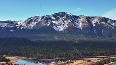 Aerial view of snow capped Mount Tallac in South Lake Tahoe with forest and water