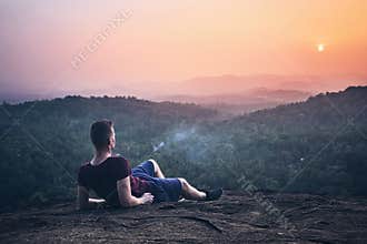 Man contemplation on top of rock