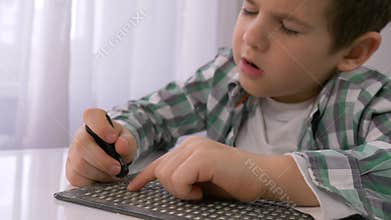 Education of blind children, sick little boy learning to write characters font Braille at table in bright