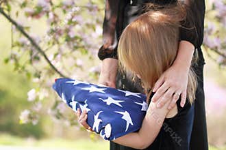 Child Holding a Parent's Folded American Flag