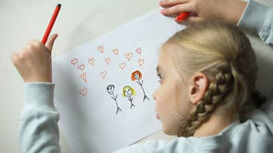 Little girl painting family with heart signs, orphan dreaming about parents