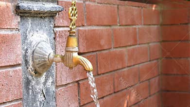Vintage old fountain flowing water and brick wall