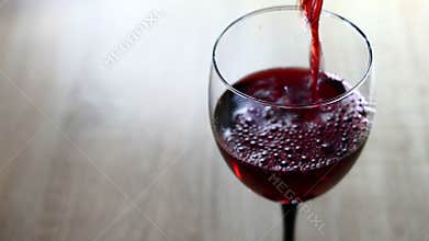 Red wine pouring into a glass