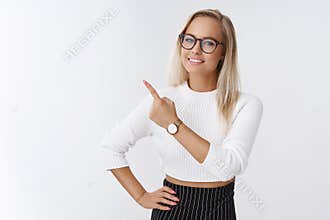 Indoor shot of successful good-looking energized creative female entrepreneur with fair hair in glasses and watch