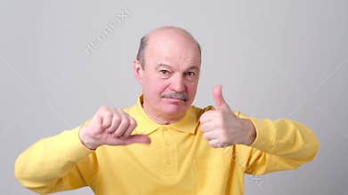 Man trying to make a desicion making good or bad sign.