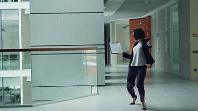 Carefree office worker is dancing in lobby holding paper then throwing folder away and relaxing moving body. Modern