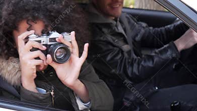 Couple photographing while sitting in car