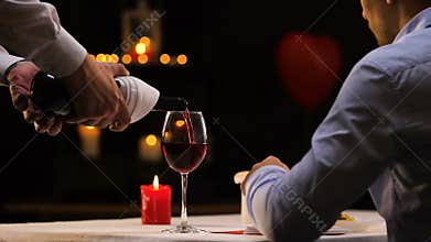 Guy having supper and drinking wine, celebrating Saint Valentines day alone
