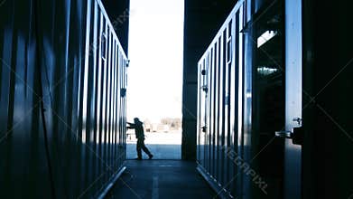 Warehouse worker opening metal door.