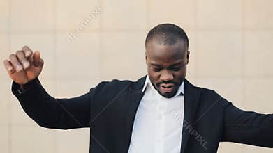 Happy, successful african american businessman throwing money to camera. Money rain, falling dollars. Slow motion