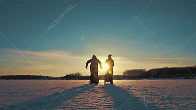 Happy family at sunset. Father, mother and little son are having fun and playing on snowy winter walk in nature.